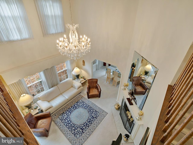 carpeted living room with a chandelier and a high ceiling