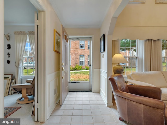 doorway featuring light tile patterned floors and crown molding