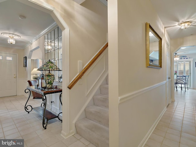 entrance foyer featuring ceiling fan, light tile patterned floors, and crown molding