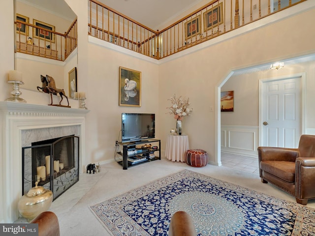 carpeted living room featuring a fireplace and a high ceiling