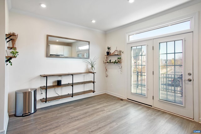 doorway with light hardwood / wood-style floors and crown molding