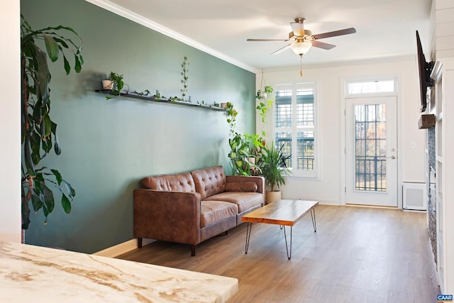 living room featuring hardwood / wood-style flooring, ceiling fan, and crown molding