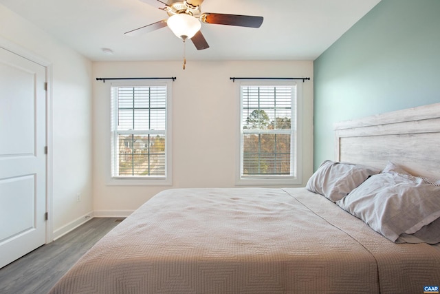 bedroom with hardwood / wood-style flooring, multiple windows, and ceiling fan