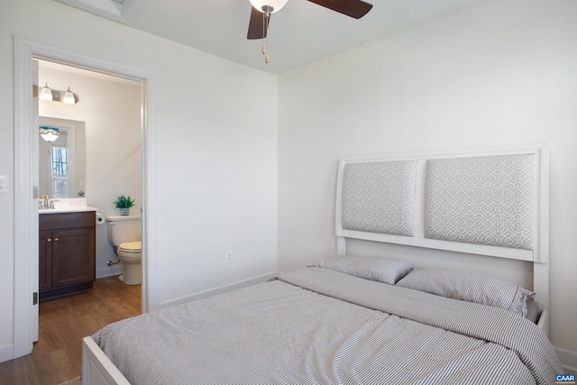 bedroom with ceiling fan, sink, wood-type flooring, and ensuite bathroom