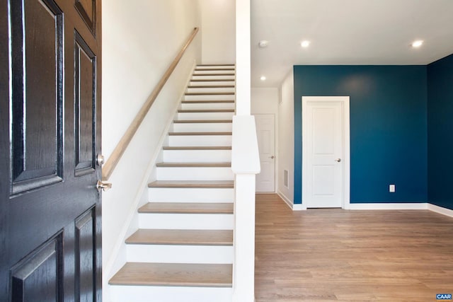 staircase with hardwood / wood-style floors