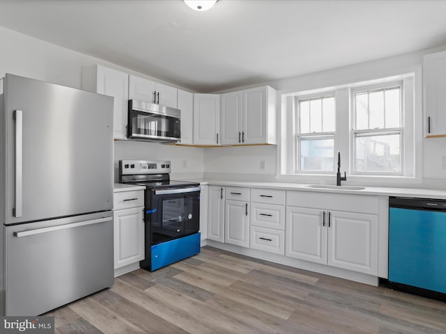 kitchen featuring light hardwood / wood-style flooring, stainless steel appliances, white cabinetry, and sink