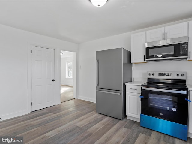 kitchen featuring light wood-type flooring, white cabinetry, and appliances with stainless steel finishes