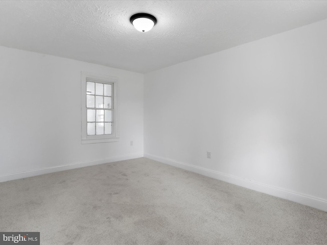 carpeted spare room featuring a textured ceiling