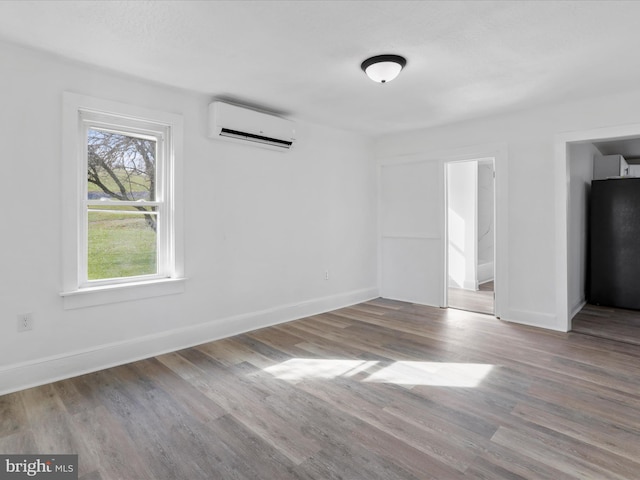 interior space with a wall mounted AC and light hardwood / wood-style flooring