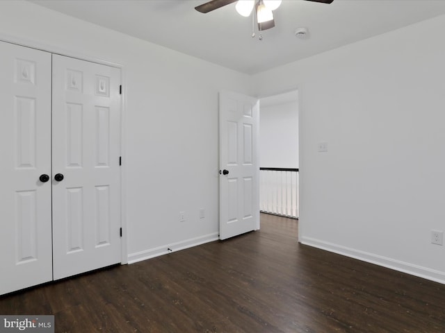 unfurnished bedroom with ceiling fan, dark hardwood / wood-style flooring, and a closet