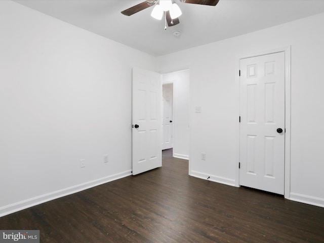 unfurnished bedroom featuring ceiling fan and dark hardwood / wood-style flooring