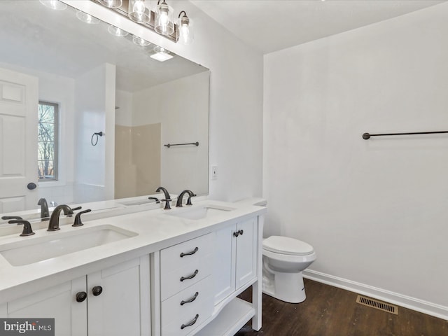 bathroom with walk in shower, vanity, wood-type flooring, and toilet