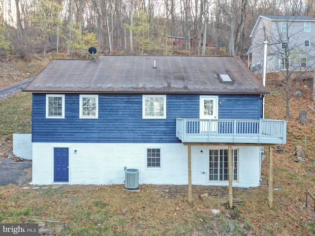 rear view of house with central AC unit and a wooden deck