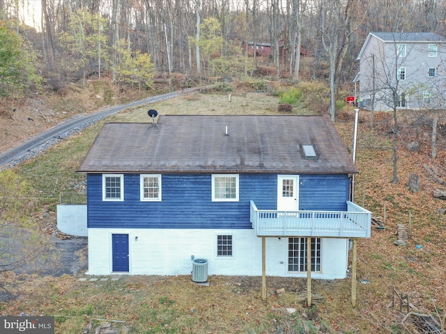 back of property with central AC unit and a deck