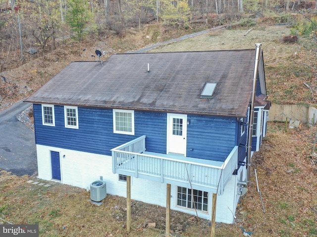 rear view of property featuring central AC and a deck