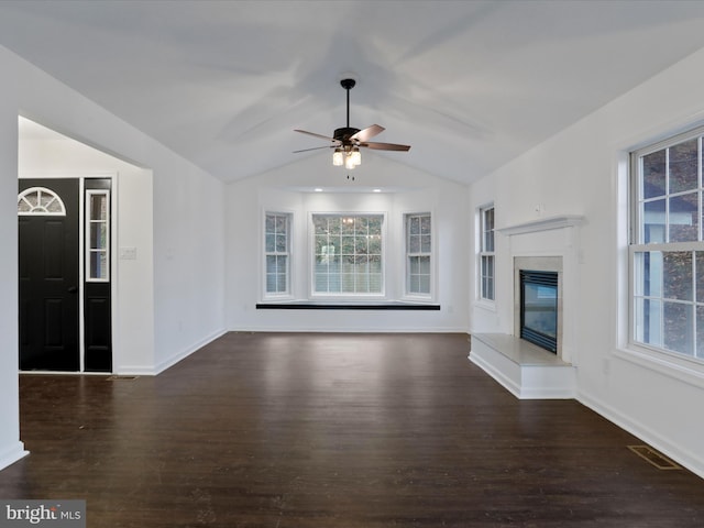 unfurnished living room with lofted ceiling, ceiling fan, a healthy amount of sunlight, and dark hardwood / wood-style floors