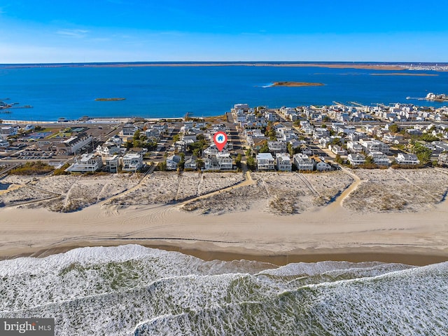 drone / aerial view with a water view and a beach view