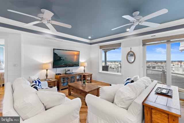 living room featuring a tray ceiling, ceiling fan, and hardwood / wood-style flooring