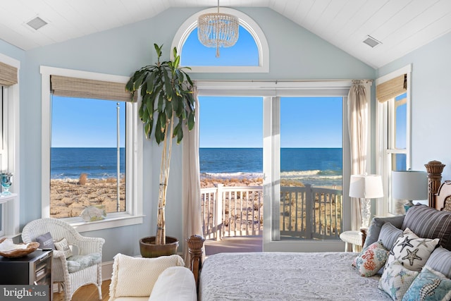 bedroom with a chandelier, a water view, a beach view, and vaulted ceiling