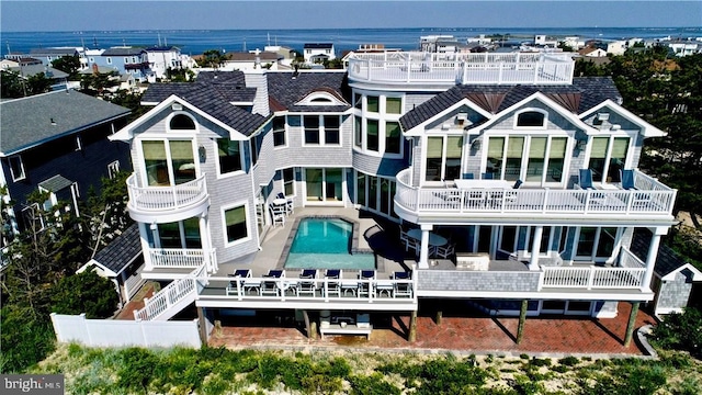 back of property featuring a water view and a patio