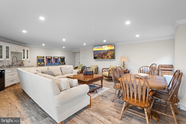 living room featuring light hardwood / wood-style floors, ornamental molding, and sink