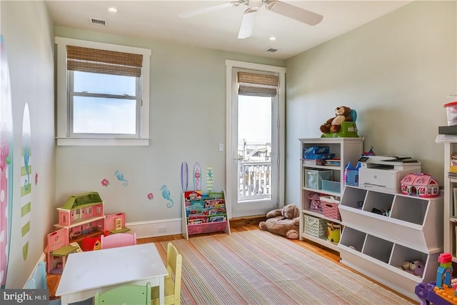 game room with light hardwood / wood-style flooring, ceiling fan, and a healthy amount of sunlight