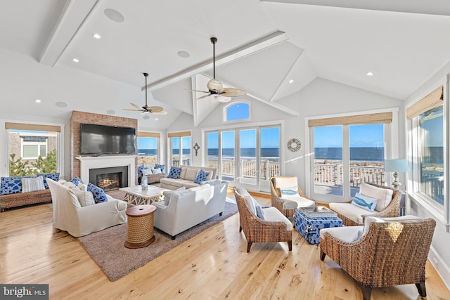 living room with ceiling fan, light hardwood / wood-style floors, beam ceiling, and high vaulted ceiling