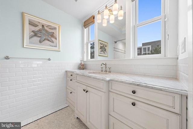 bathroom with tile patterned floors, vanity, and tile walls