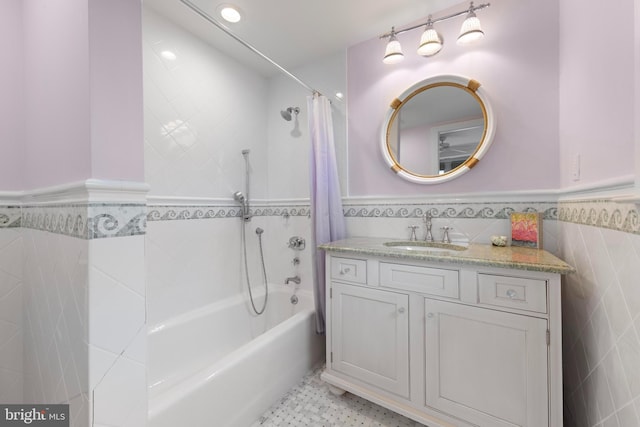 bathroom featuring shower / bath combination with curtain, vanity, and tile walls