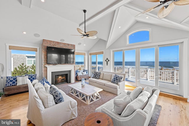 living room featuring beamed ceiling, high vaulted ceiling, and light hardwood / wood-style flooring