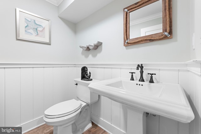 bathroom featuring sink, toilet, wood-type flooring, and ornamental molding