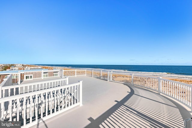 balcony featuring a view of the beach and a water view