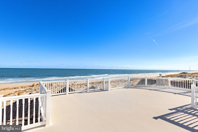 view of patio with a water view and a beach view