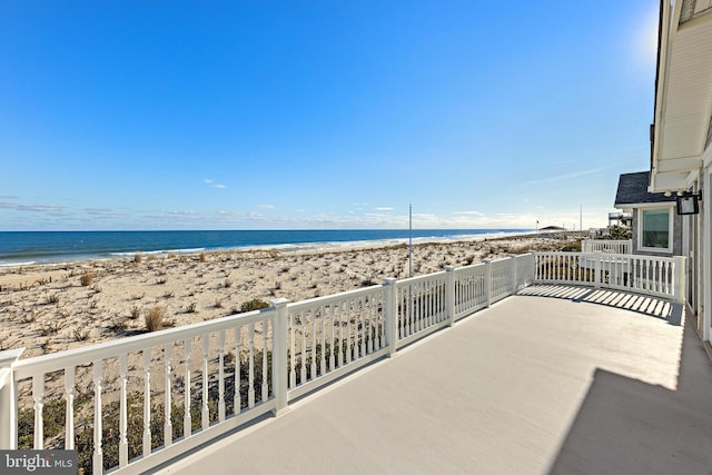 balcony featuring a view of the beach and a water view