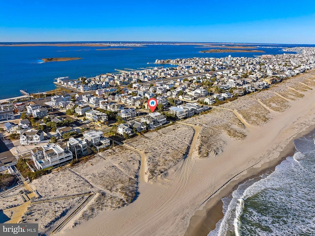 drone / aerial view featuring a water view and a beach view