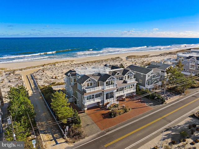 drone / aerial view featuring a water view and a view of the beach