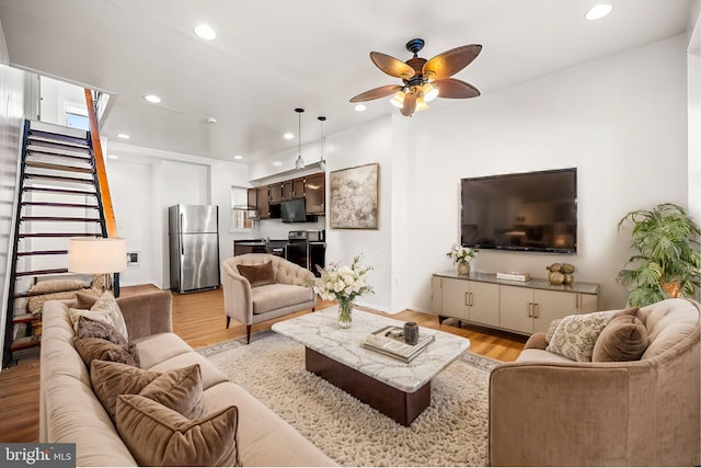 living room with light wood-type flooring and ceiling fan