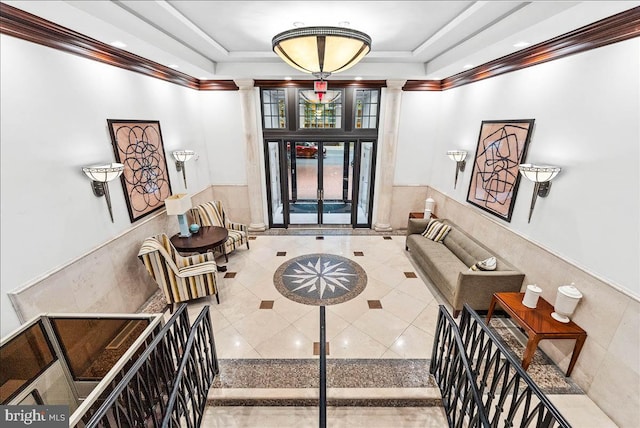 entrance foyer featuring a tray ceiling, tile walls, and crown molding