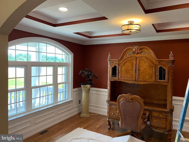 home office featuring light hardwood / wood-style floors, a raised ceiling, and ornamental molding