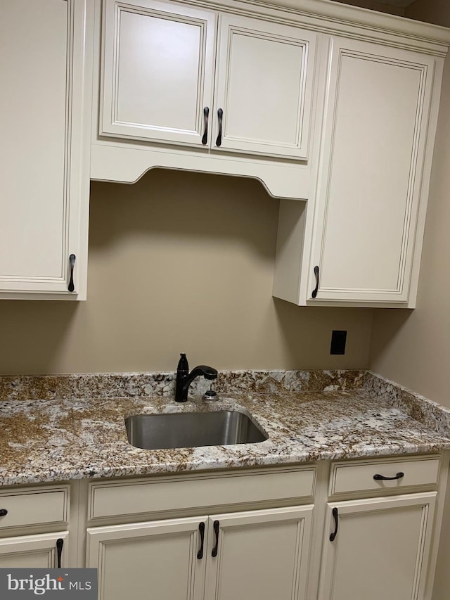 kitchen featuring light stone countertops and sink