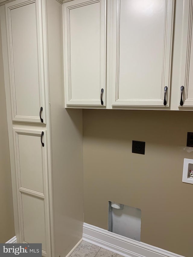 washroom with electric dryer hookup, cabinets, light tile patterned floors, and hookup for a washing machine