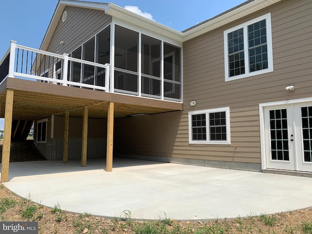 back of house with french doors, a patio, a wooden deck, and a sunroom