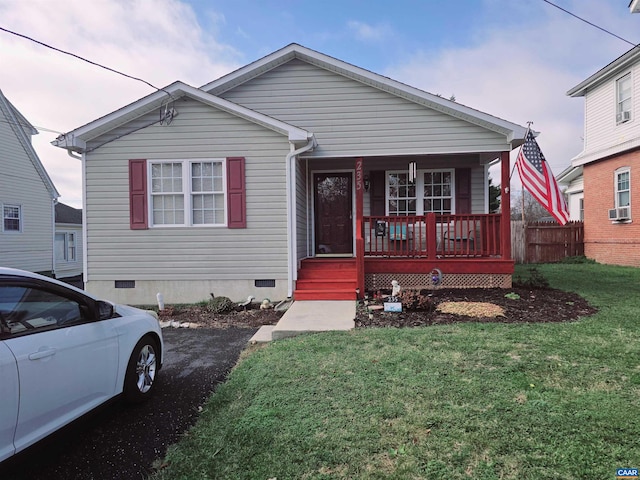 bungalow-style home featuring a yard, cooling unit, and a porch