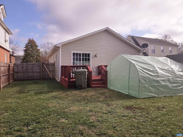 back of property featuring a deck and a yard