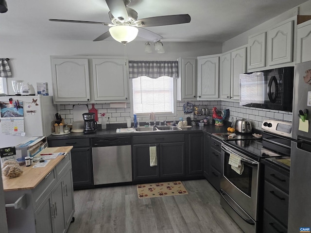 kitchen featuring decorative backsplash, light wood-type flooring, stainless steel appliances, and sink