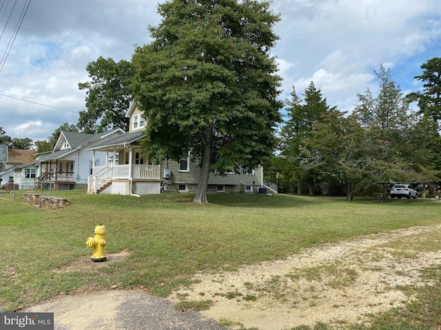 view of side of home featuring a lawn and a porch