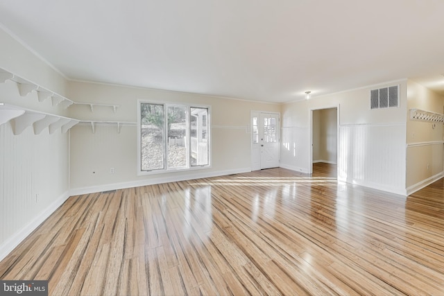 empty room featuring light hardwood / wood-style floors and ornamental molding