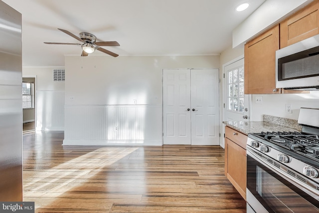 kitchen featuring light wood-type flooring, stainless steel appliances, and a wealth of natural light