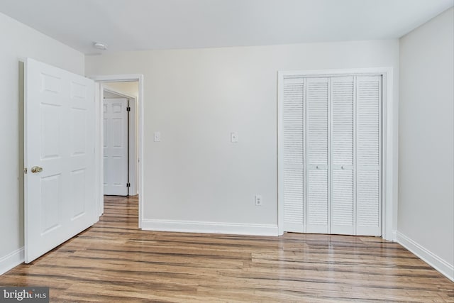 unfurnished bedroom featuring hardwood / wood-style floors and a closet