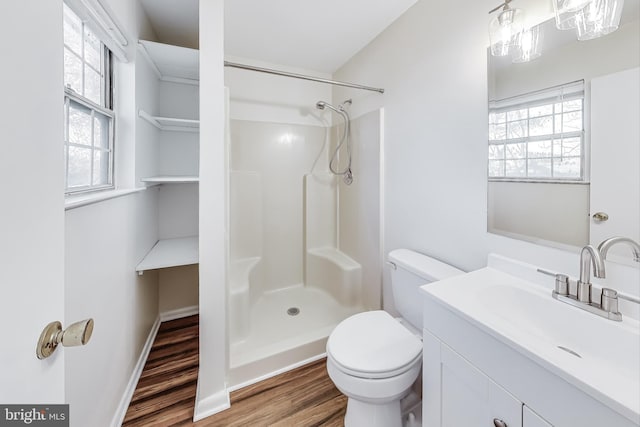 bathroom with toilet, hardwood / wood-style floors, vanity, and walk in shower